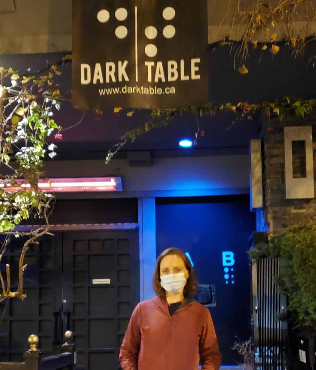 A woman poses for a photo outside a restaurant 
