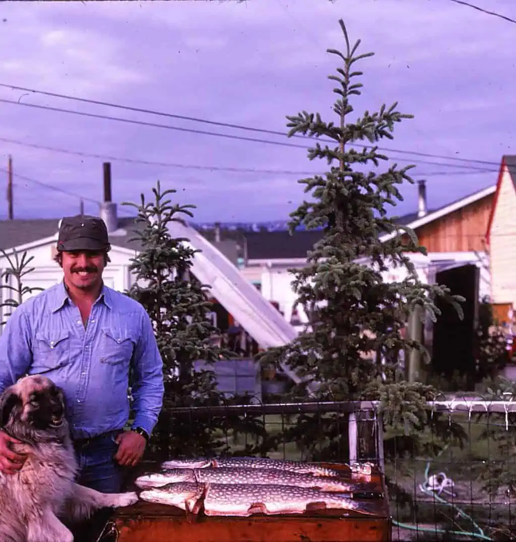 A man and a dog with freshly caught fish