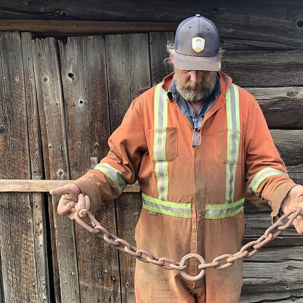 Dale Bradley holding a steel chain forged at his family's blacksmith shop