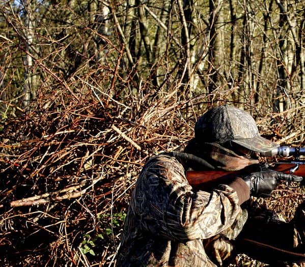 A hunter preparing to take a shot with a rifle