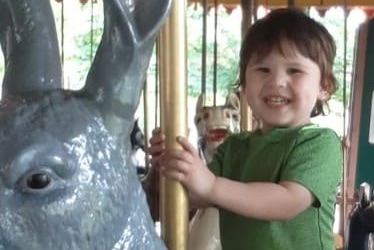 A toddler riding on a merry-go-round