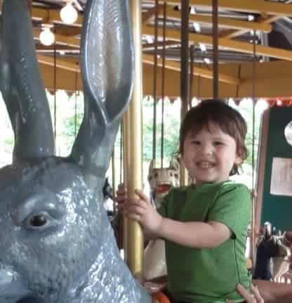 A toddler riding on a merry-go-round