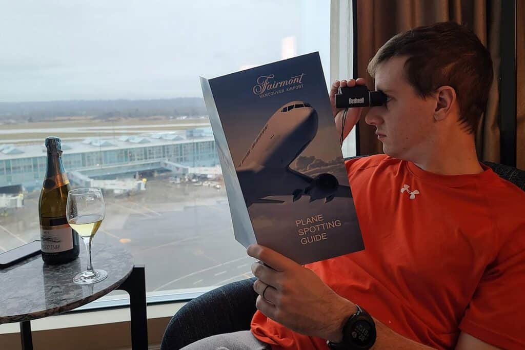 A man uses binoculars at an airport
