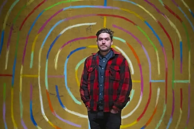 a man standing in front of an art piece