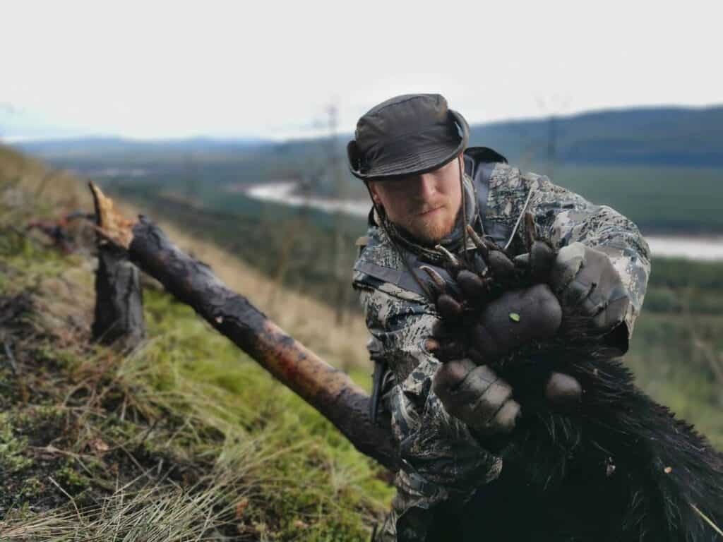 A hunter showing the size of a black bear paw