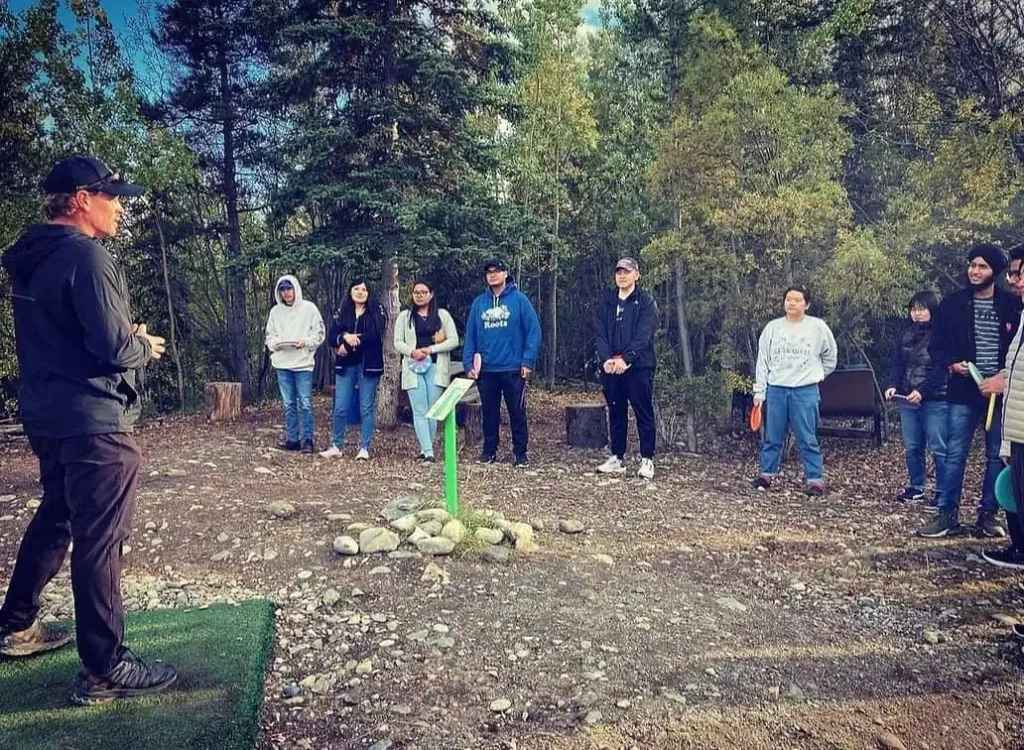 A group of eager disc golfers receive a demonstration on the sport 
